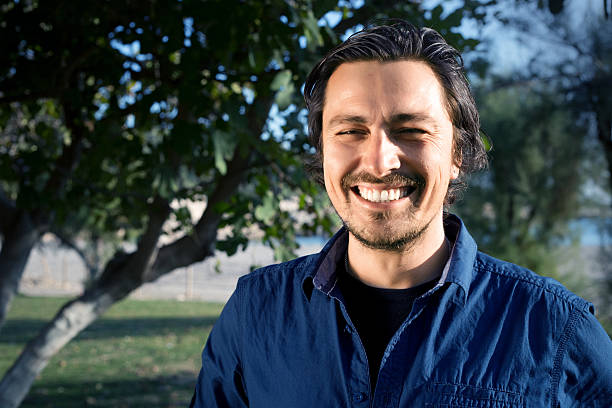 Young man in the park smiling.